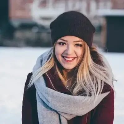 Ritratto di una donna sorridente con berretto e sciarpa