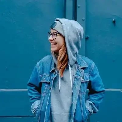 Ritratto di una donna con giacca di jeans davanti a un muro blu